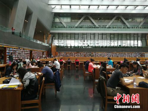 十一黄金周期间,不少人选择在图书馆度过难得的休闲时光。图为假期期间国家图书馆里的阅读者。中新网记者 张尼 摄