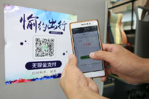 2017年8月3日，乘客在重庆市北碚区使用手机扫描二维码支付公交车费。新华社发