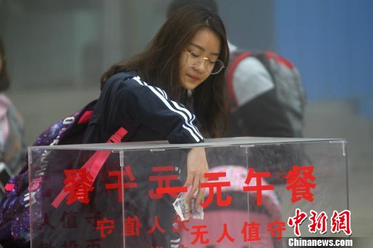 图为游客自觉投币、自助找零购买一元午餐。 王中举 摄
