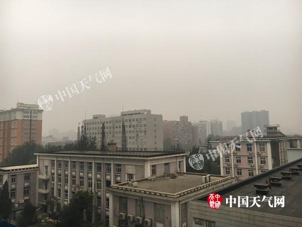 今晨7时左右北京天空阴沉,远处楼房已模糊。