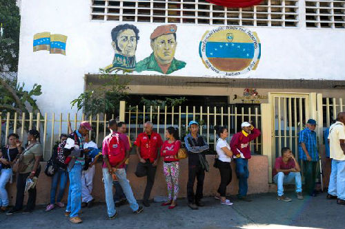 2016年12月16日，在委内瑞拉首都加拉加斯，人们在银行外排队等待兑换100玻利瓦尔纸币。（新华/法新）