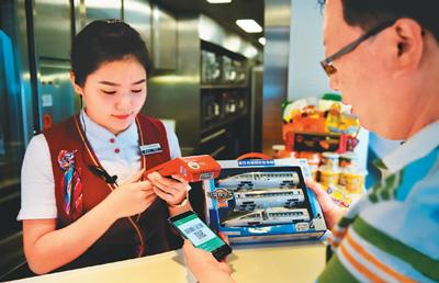 图为高铁乘客扫码进行消费。