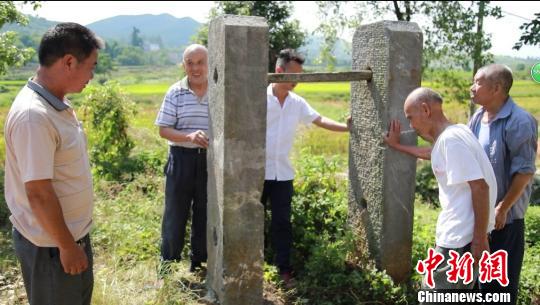 当地村民向文物部门工作人员介绍石闱子的故事。 王勇军 摄