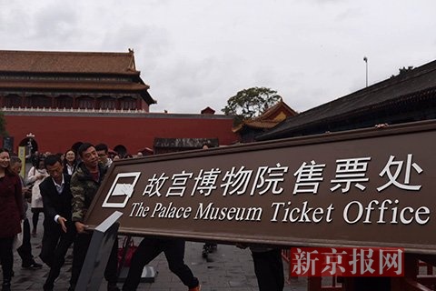工作人员摘下故宫博物院售票处的牌匾。