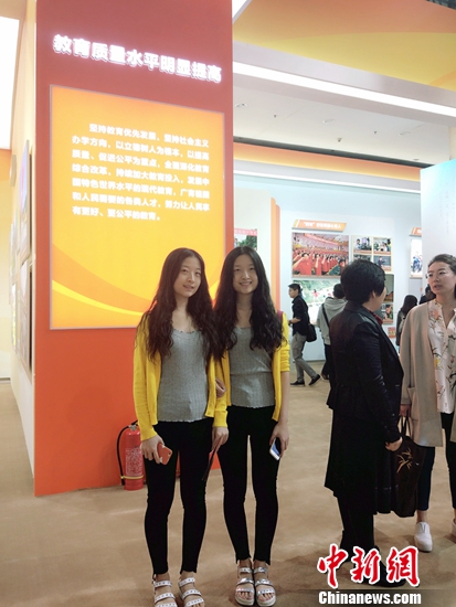 双胞胎女大学生正在参观教育成就。中新网记者 李金磊 摄