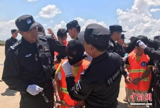 10月12日,70余名在柬埔寨涉嫌网络诈骗的中国嫌犯,在柬移民局警方和中国警方押送下从金边机场被遣返。中新社记者 钟欣 摄