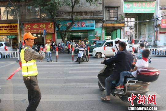 图为柳石路小学家长义工服务队在学校门口马路指挥交通 林馨 摄