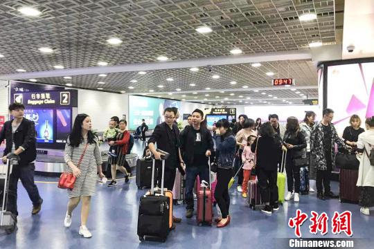 图为旅客16日上午乘机抵达三亚凤凰国际机场。　王祯　摄