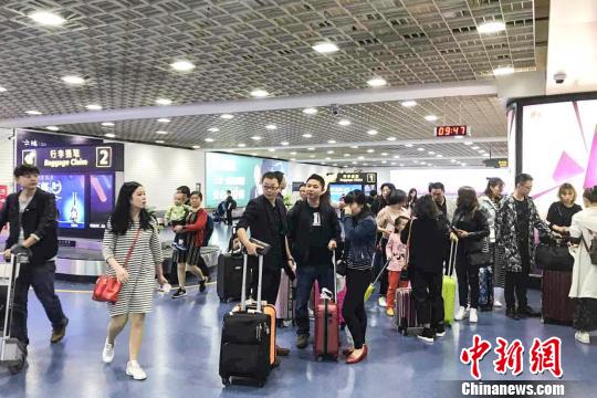图为游客16日上午乘机抵达三亚凤凰国际机场。 王祯 摄