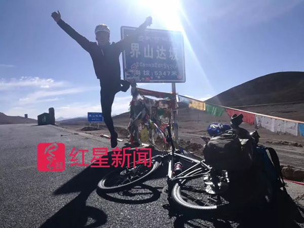 在界山达坂路牌旁,激动跃起的孙有志