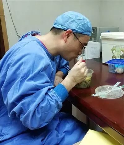 手术的间隙,葛卫力在吃已经涨了的面条.jpg