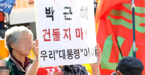 1508746327750918.png 21日,韩国民众手持标语“别惹朴槿惠!”