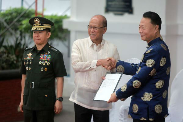 10月5日，在菲律宾马尼拉，中国驻菲大使赵鉴华（右）、菲国防部长洛伦扎纳（中）和武装部队总参谋长阿诺出席移交仪式。 （新华社）