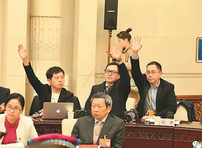  本报记者刘少华（后排左一）在云南代表团开放日举手提问。
