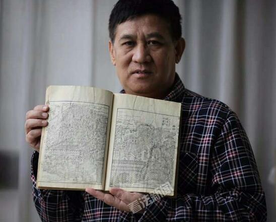 图为:贾英华先生向记者展示1805年版《唐土名胜图会》中的乾清宫千叟宴 摄/法制晚报·看法新闻 记者崔毅飞