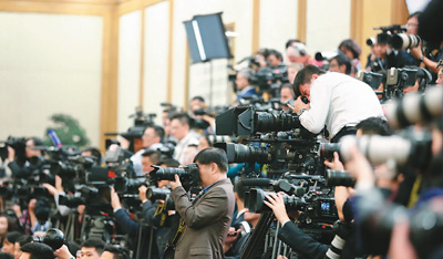  10月25日，中共十九届中央政治局常委在北京人民大会堂同采访十九大的中外记者见面。图为记者在采访拍摄。 　　新华社记者 殷 刚摄