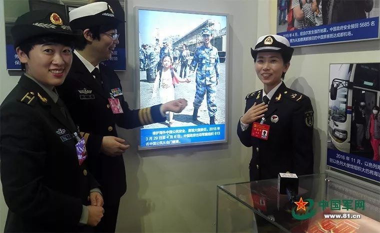 海军临沂舰女兵郭燕(右一)在“砥砺奋进的五年”大型成就展中,看到了2015年自己参与也门撤侨行动时的“网红照”。中国军网记者 冯凯旋摄