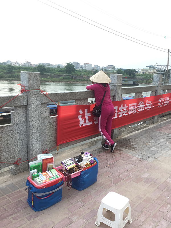 没有顾客，阿丽有时会趴在护栏边，眺望北仑河，河的对岸就是越南芒街。