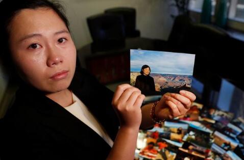  陈怡菁举着母亲的照片。（图源：《洛杉矶时报》）