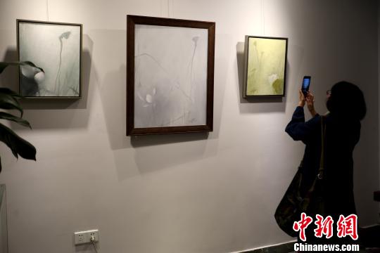 观众用手机拍摄油画荷花艺术作品。 张浪 摄