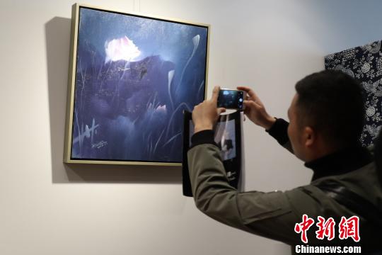 观众用手机拍摄油画荷花艺术作品。 张浪 摄