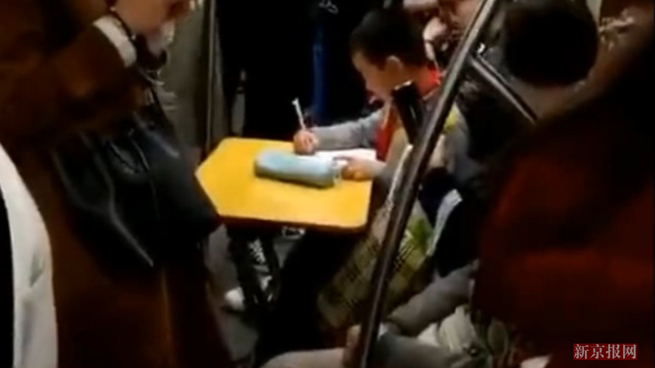 服!小学生带折叠桌地铁上赶作业 母亲:做了三道