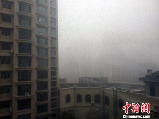 乌鲁木齐大雾，新市区鲤鱼山路楼宇被雾气包围。　赵晓咏 摄