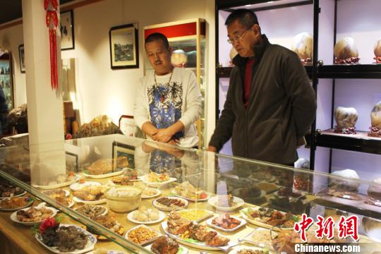 图为兰州收藏爱好者张积平(左一)在黄河石科普知识馆内与石友交流。 徐雪 摄