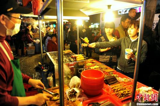 资料图：大陆游客在台北士林夜市品尝美食。中新社发 王东明 摄