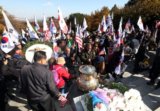 1510640915107678.jpg 14日,韩国民众手挥太极旗星条旗参加纪念活动