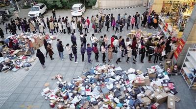 双11过后郑州高校快递堆积如山 排队取快递场