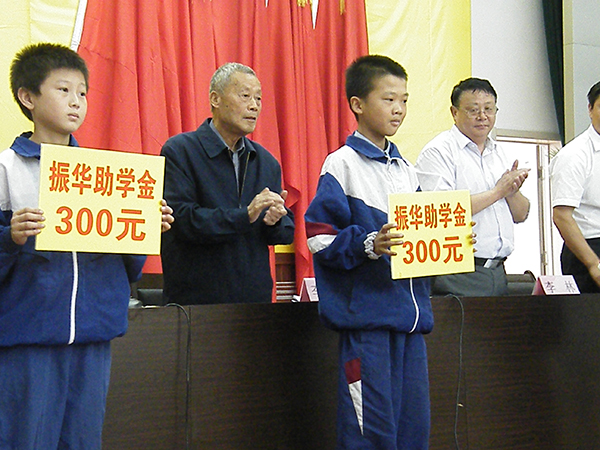 李振华在“振华奖学扶贫基金会”上给学生颁发助学金。