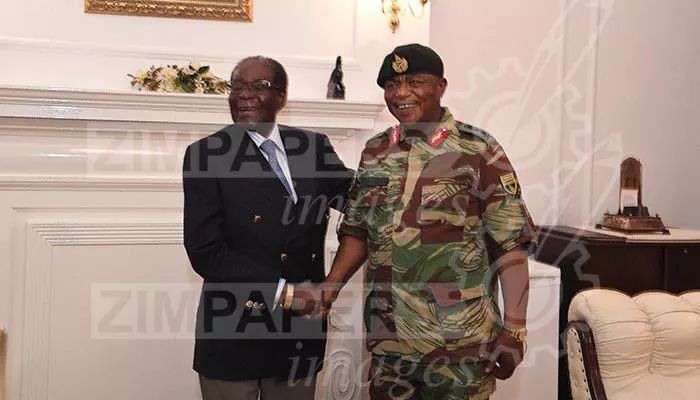 穆加贝与津巴布韦武装部队总司令奇温加微笑握手。