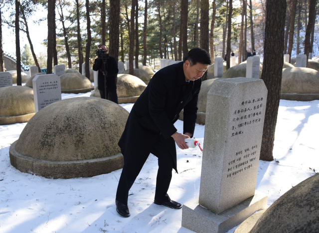 11月19日，在桧仓中国人民志愿军烈士陵园墓园内，宋涛在一尊烈士墓前躬身祭酒。（新华社记者程大雨摄）