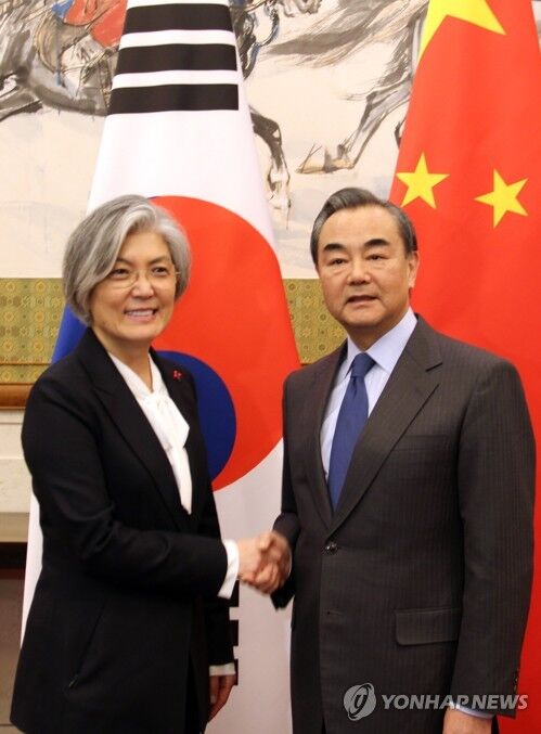 资料图:11月22日下午,在北京钓鱼台国宾馆,韩国外交部长官康京和(左)同中国外交部长王毅举行中韩外长会谈前握手。(韩联社)
