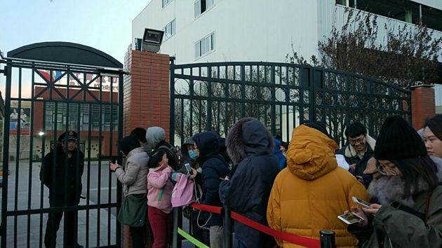 ▲下午4点40分左右，家长们在幼儿园门口等待孩子放学，校门口被围栏隔成两道，小门留作接孩子，大门没有开启