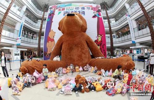资料图：一只高度达20米的毛绒玩具熊在山西太原一大型商场亮相，吸引了众多市民前来观看。