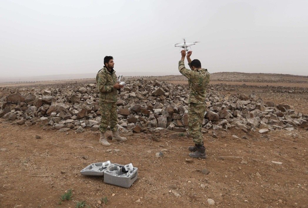 叙利亚叛军的两名战士在对抗政府军时使用无人机。