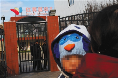11月22日，家长报警称，红黄蓝幼儿园新天地分园虐童。23日，幼儿园大门紧闭，一附近居民带着孩子来查看。新京报记者 王嘉宁 摄