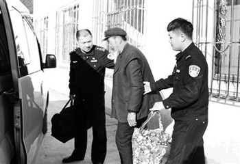 11月20日上午，民警宁树鑫（左）提着行李、扶着王老汉上车，和救助站工作人员一起要把老人送回家乡。 本文图片均为警方供图