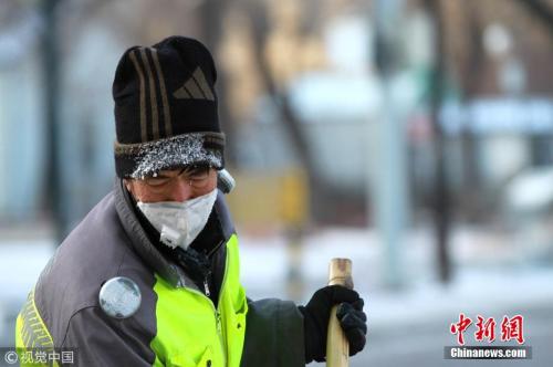 资料图：2017年11月18日，黑龙江省哈尔滨市，清晨时的温度达到-17℃。一些在室外时间长些的市民、保洁员，口罩与帽子上挂着哈气结成的白霜。图片来源：视觉中国