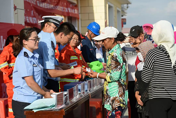 派出所民警在“民生集市”上向群众发放新办理的身份证。 彭源 摄