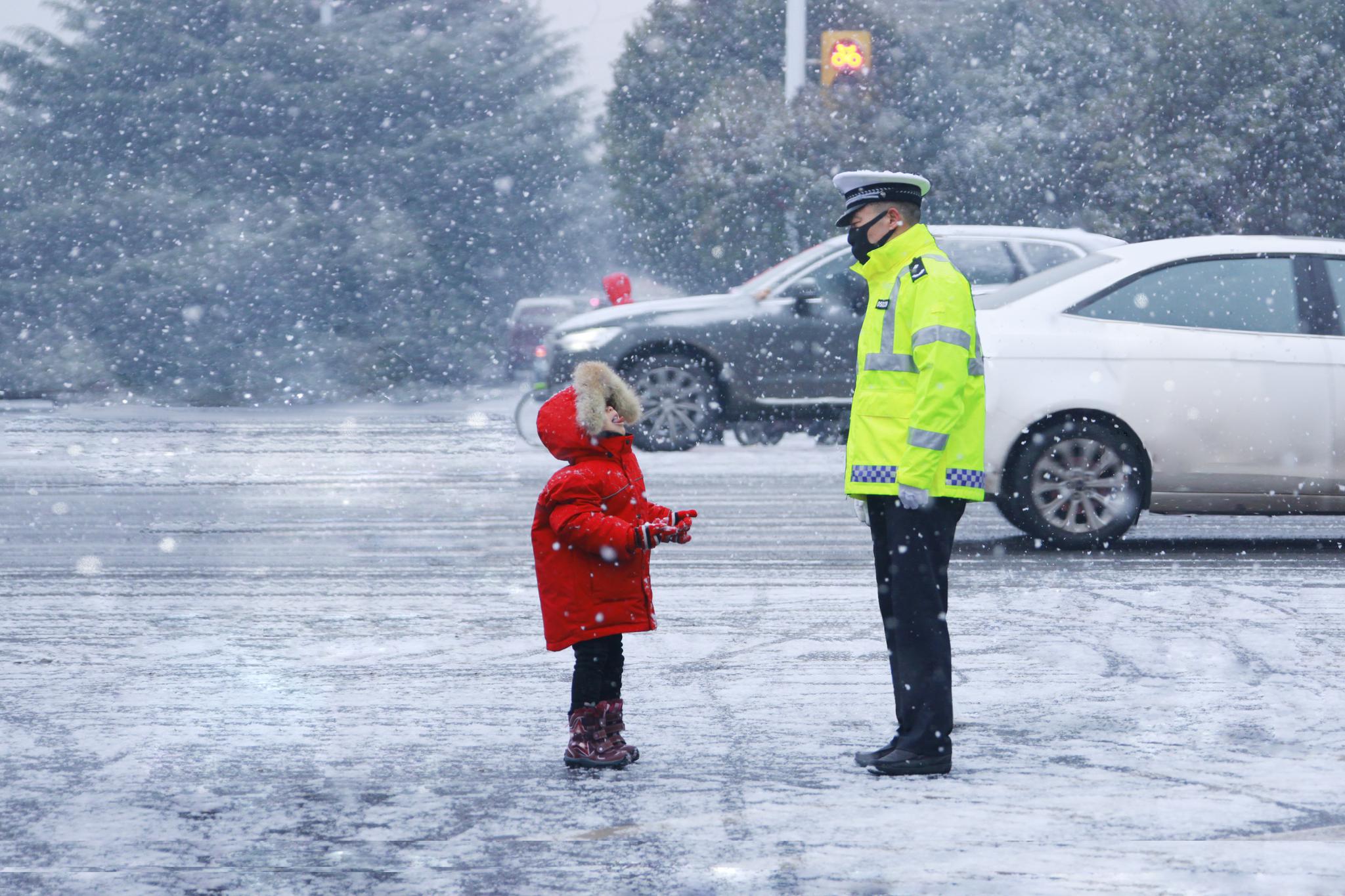 雪中，孩子向执勤交警做鬼脸:叔叔，笑笑就不冷了