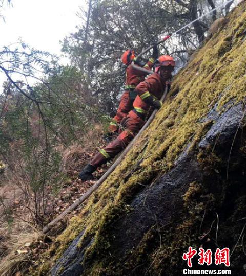 陡峭的山崖上消防員正在進行滅火作業。 馬道建 攝