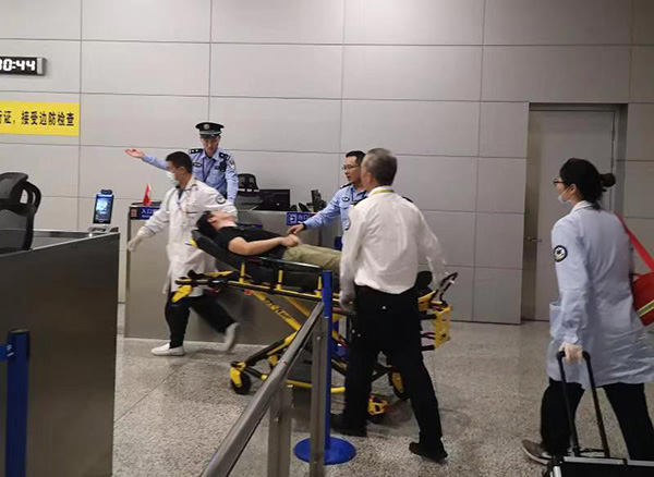边检民警和机场医护人员紧急救治患病旅客