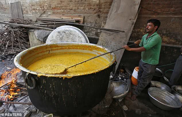  印度民众正在熬煮咖喱。（图源：路透社）