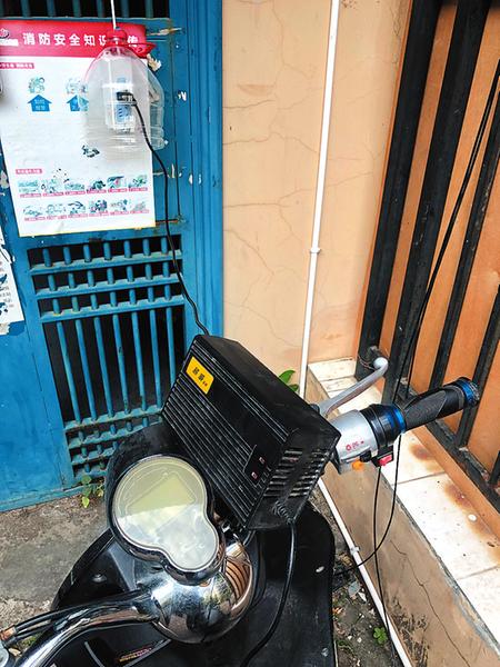 某小区居民从楼上私拉电线给电动自行车充电 记者宋延康摄