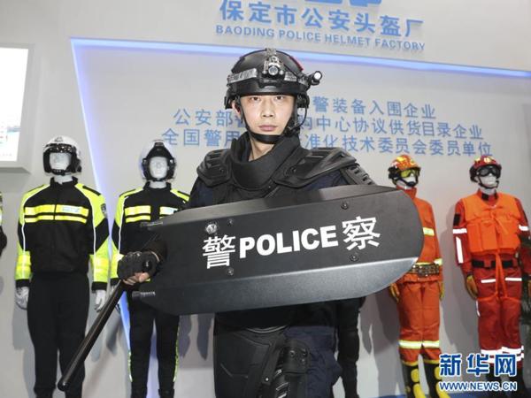 5月15日,在博览会上,一位工作人员在展示警用防暴装备.