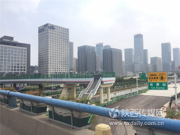 人行天桥被通往丈八收费站的道路阻隔，成了一座“孤岛”。