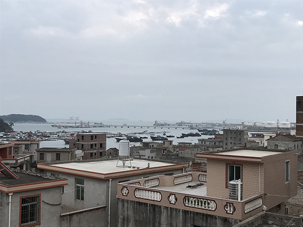 人多地少的肖厝村,可见远处的渔排和化工厂。